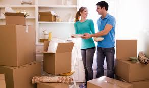 Tips for making moving easier, couple in their new home surrounded by moving boxes.