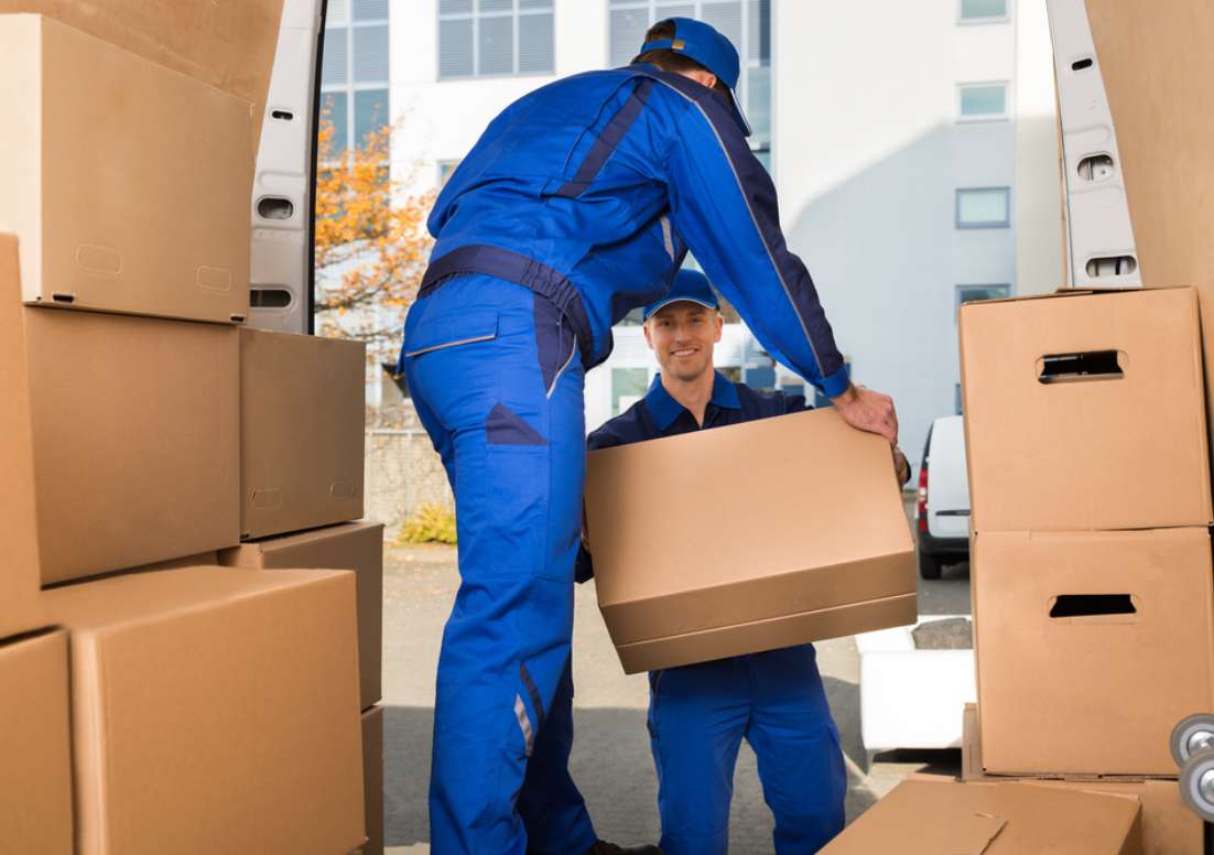 a man at faulkner removals pass a box to another man while doing an office removals job